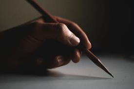 Hand holding pencil, writing