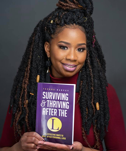 Author Tecora Harvey with her paperback book