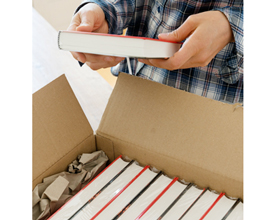 Person holding a book over open box of books